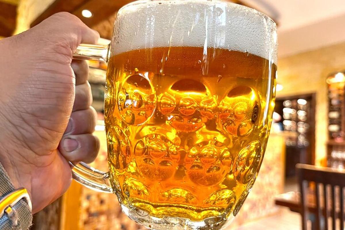 egy személy, aki egy korsó sört tart a kezében