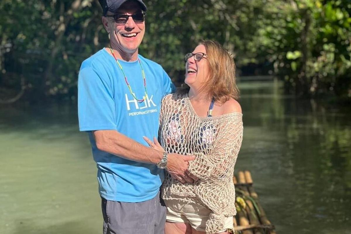 un uomo e una donna in piedi accanto a uno specchio d'acqua