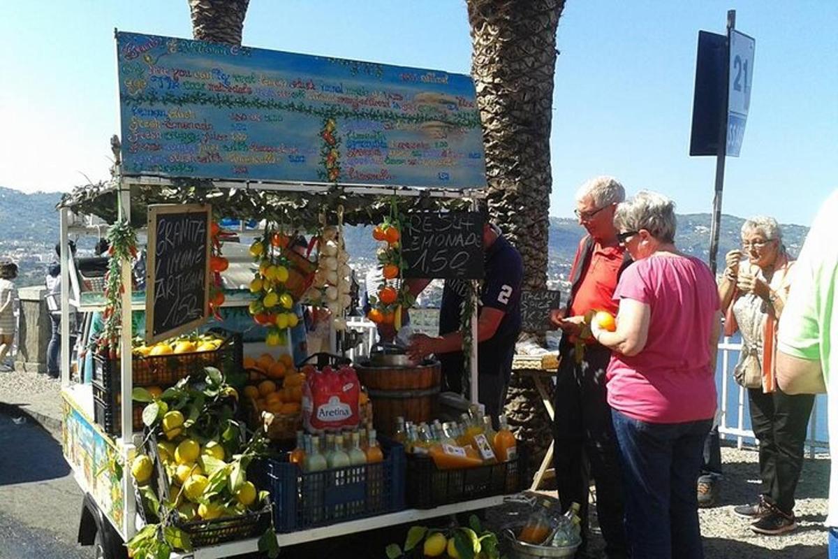 un grup de oameni care stăteau în jurul unei tarabe cu fructe