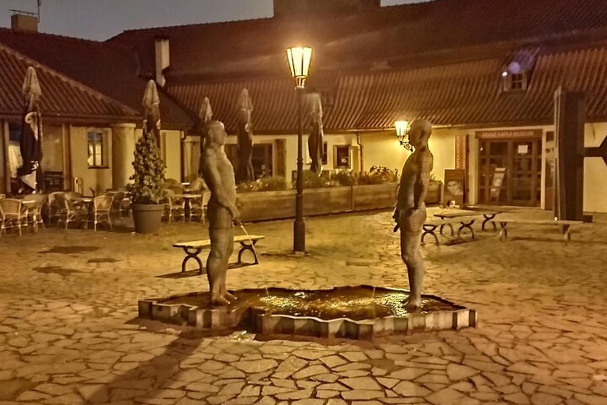 dvě sochy lidí stojících v noci na nádvoří
