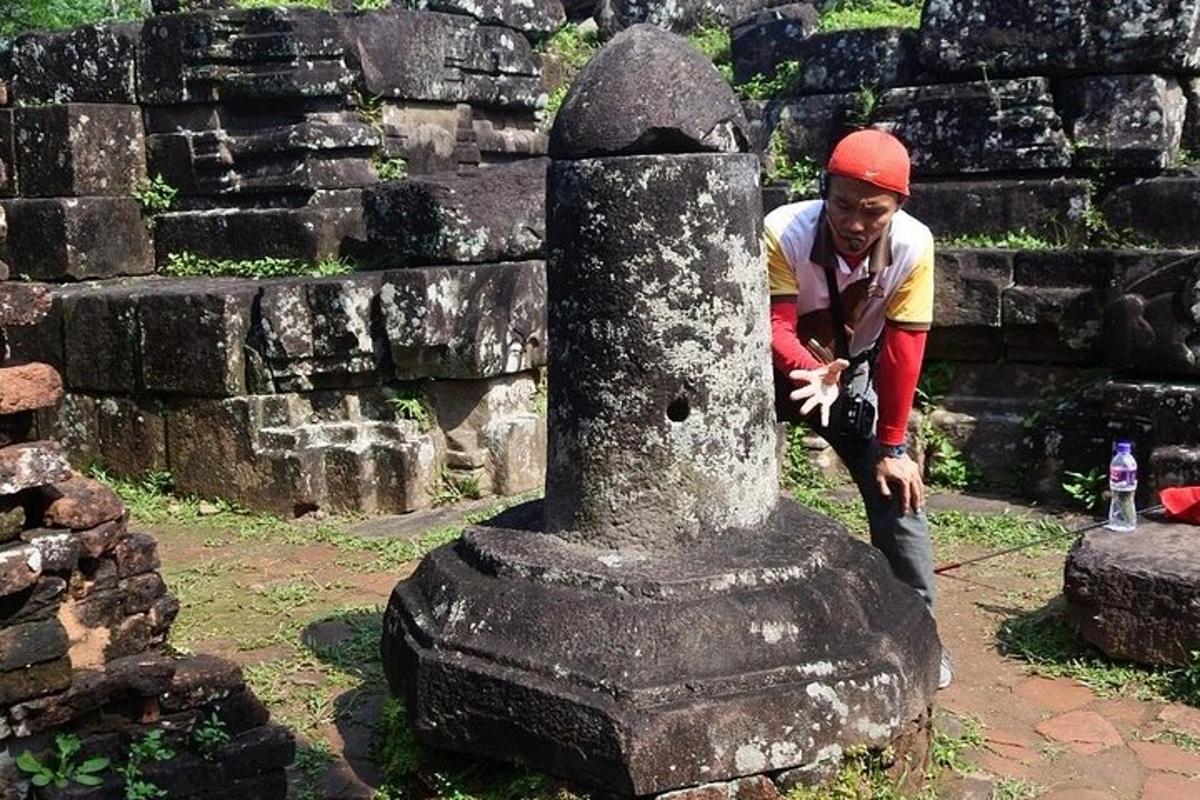 um homem está parado ao lado de um monumento de pedra