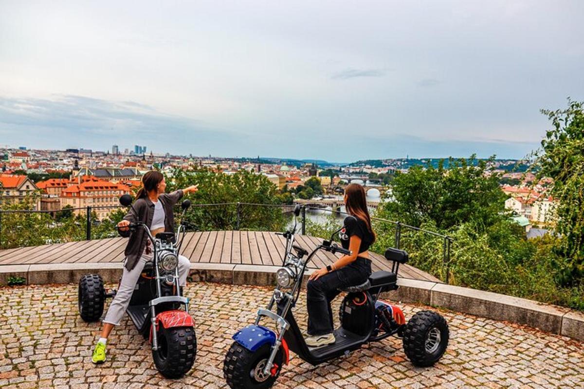 Dve dekleti sedita na svojih skuterjih na vrhu mesta