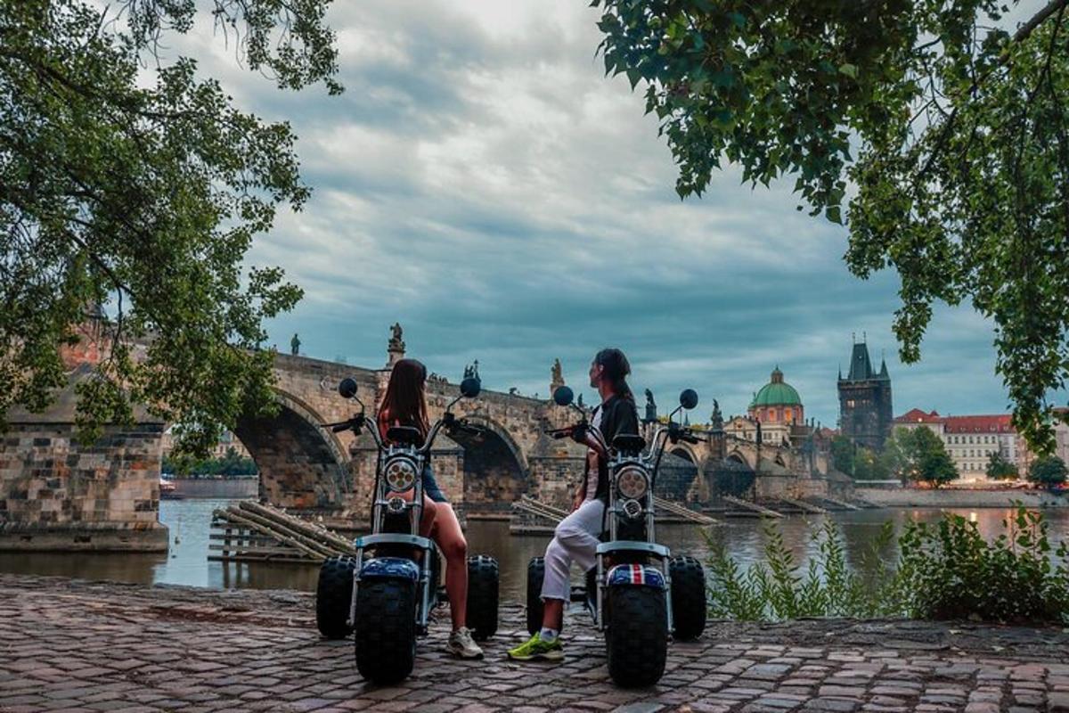 skupina ľudí sediacich na motorkách pred mostom