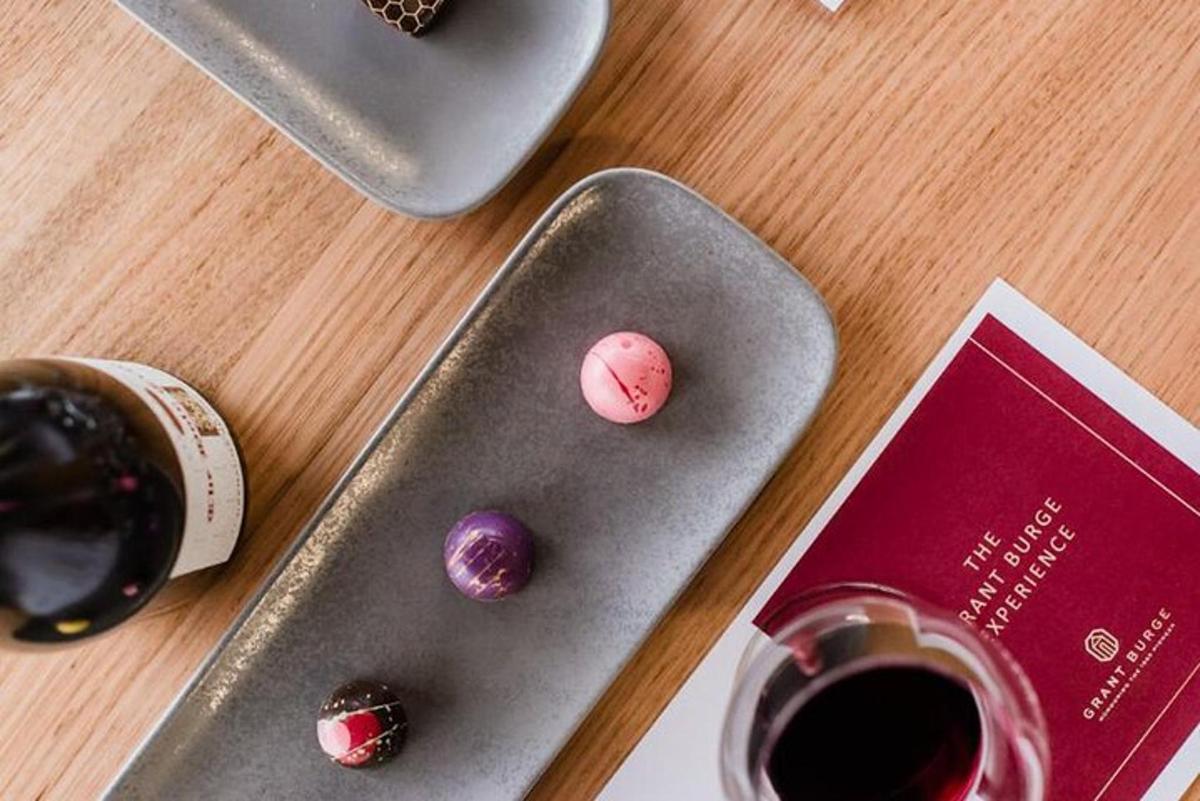 o masă cu o farfurie cu ciocolată și o sticlă de vin