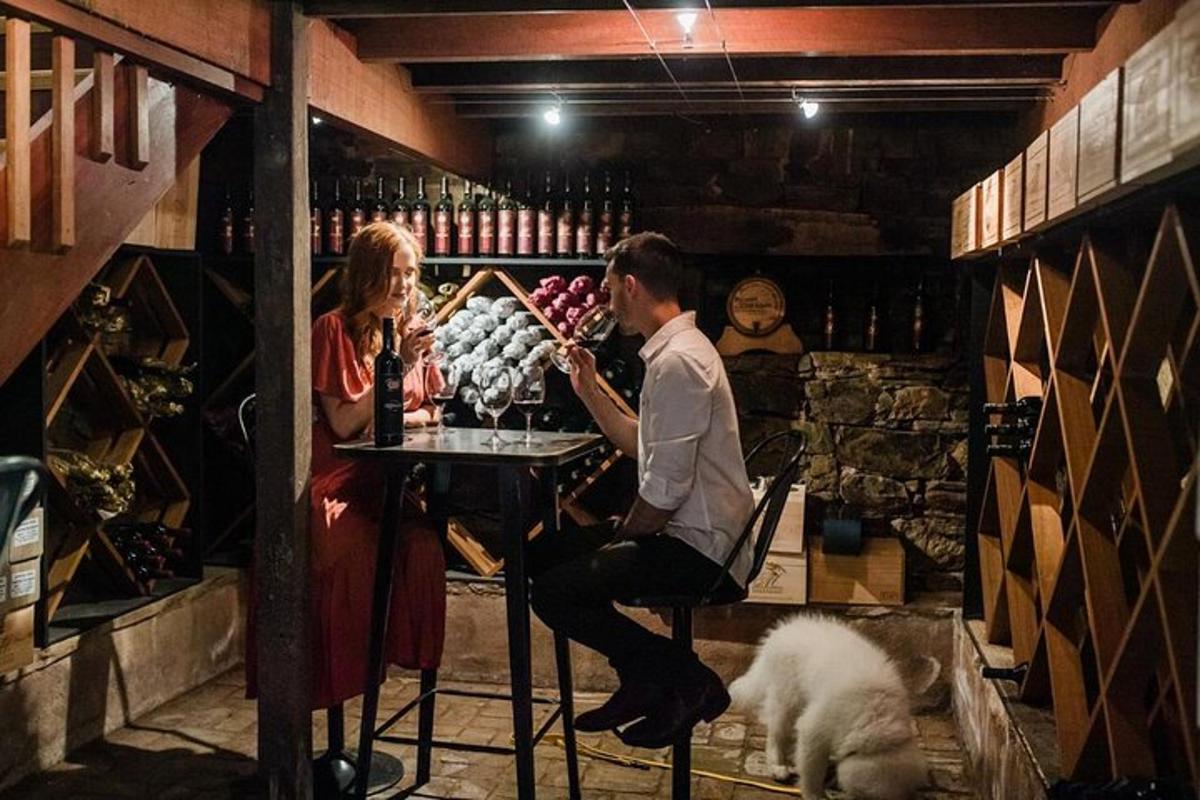 un bărbat și o femeie așezați la o masă într-un magazin de vinuri