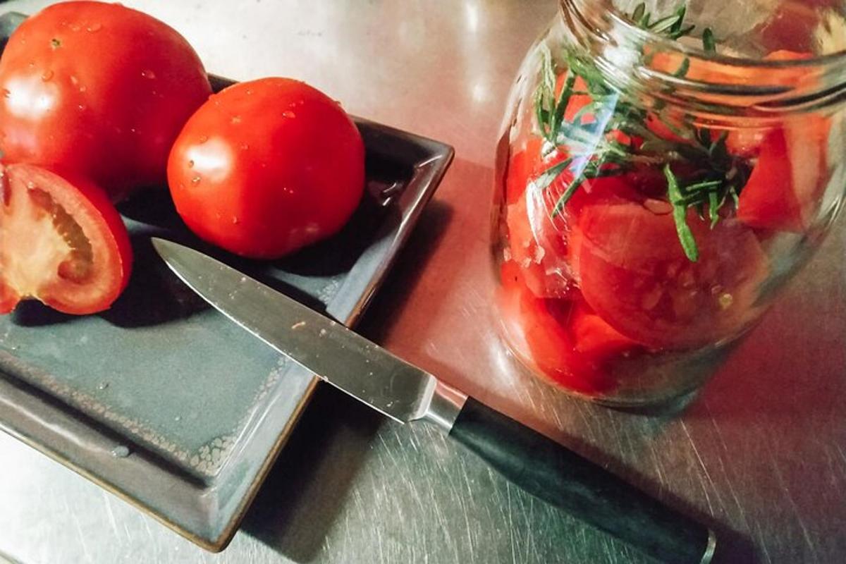 en kniv og et glass tomater på et bord