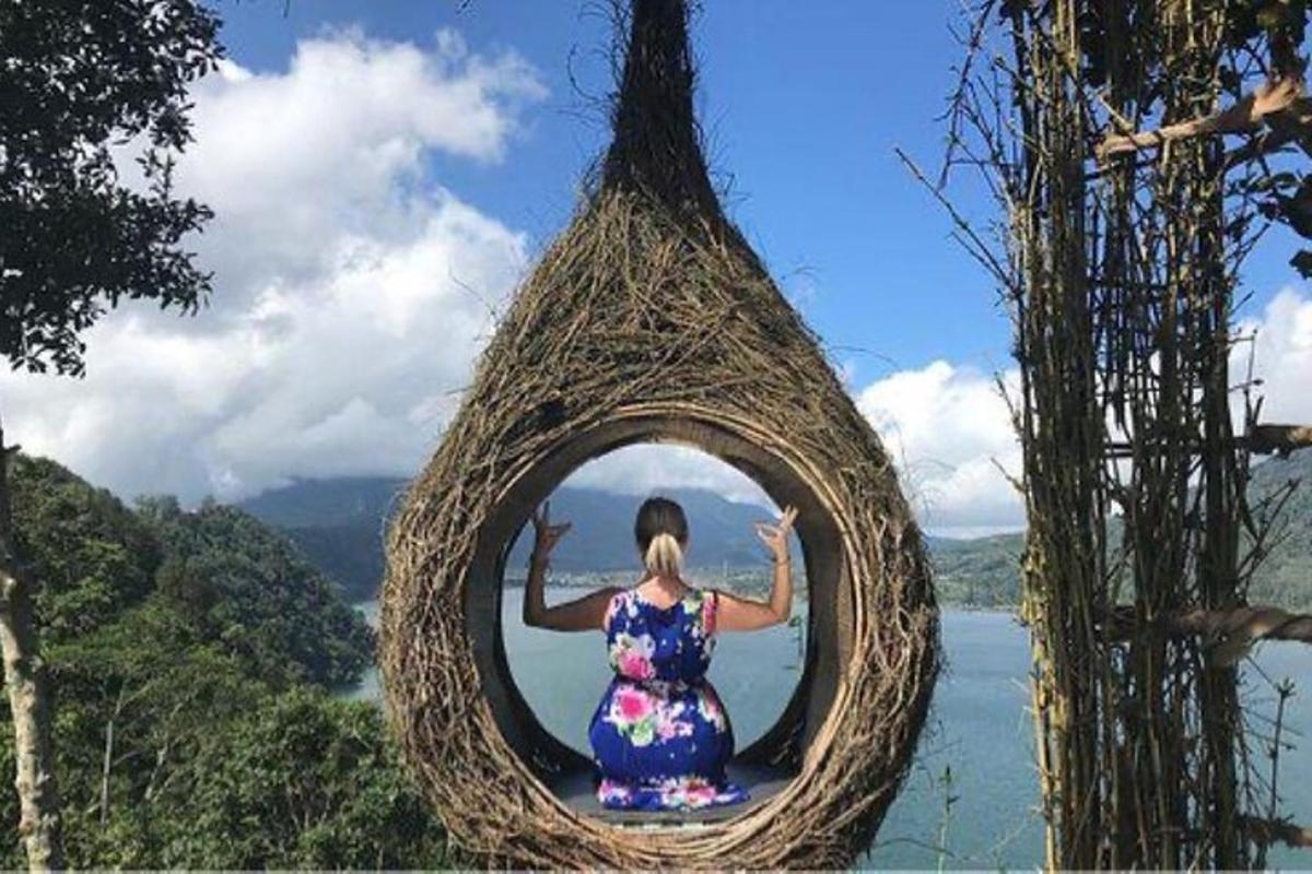 uma mulher está sentada em uma cesta suspensa com vista