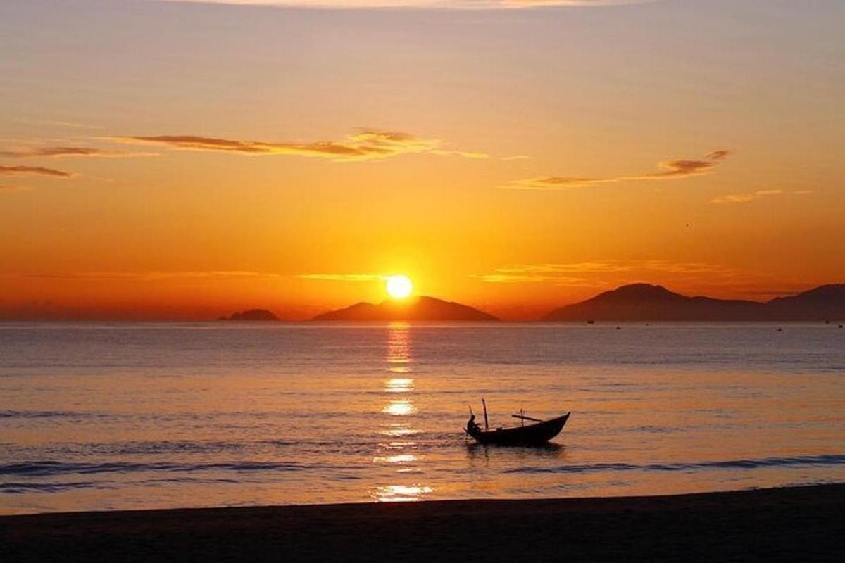bot duduk di pantai pada waktu matahari terbenam