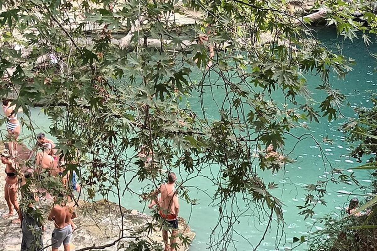 μια ομάδα ανθρώπων που στέκονται στην όχθη ενός ποταμού
