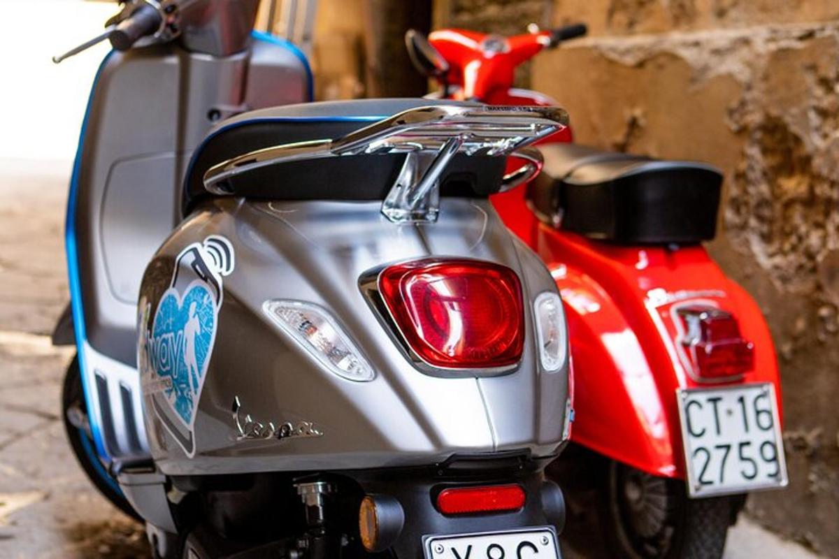 a red scooter parked on the side of a street