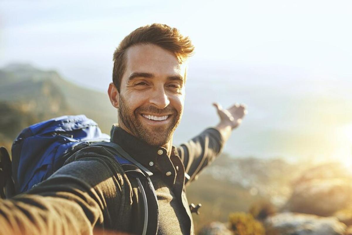 un uomo con il braccio teso su una montagna