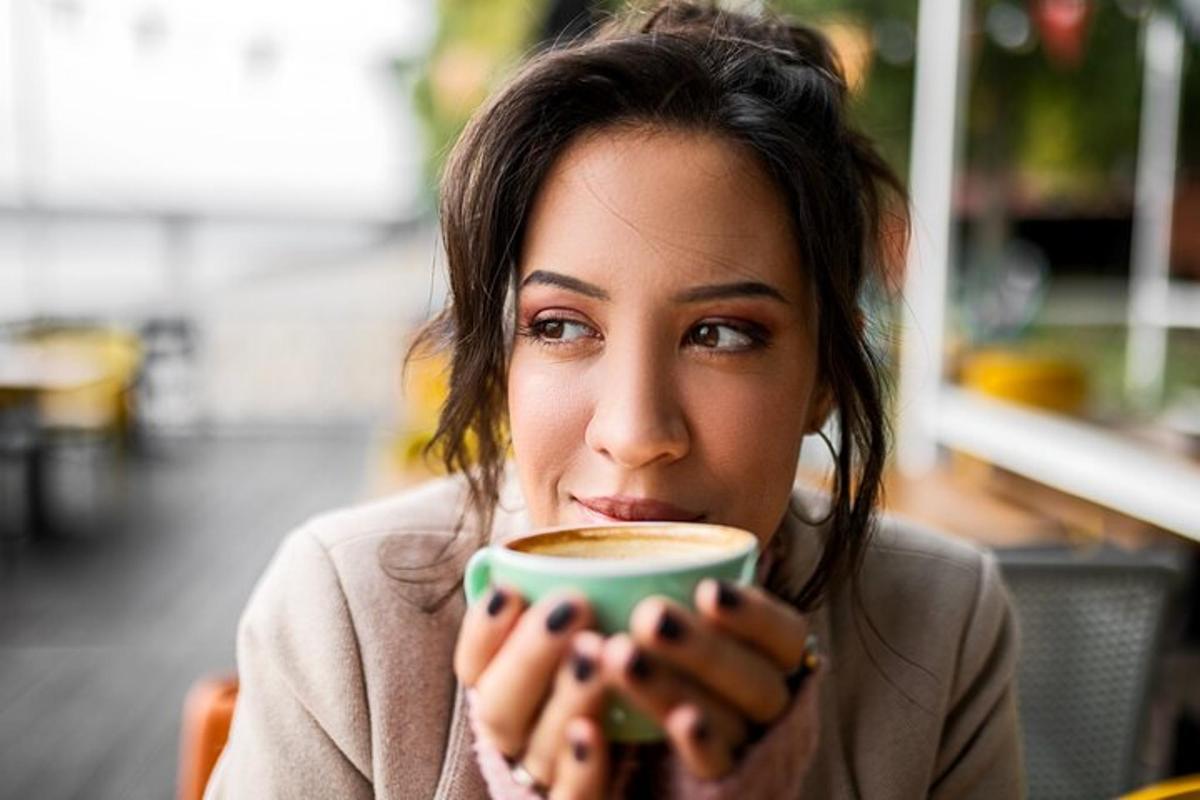 una donna tiene in mano una tazza di caffè