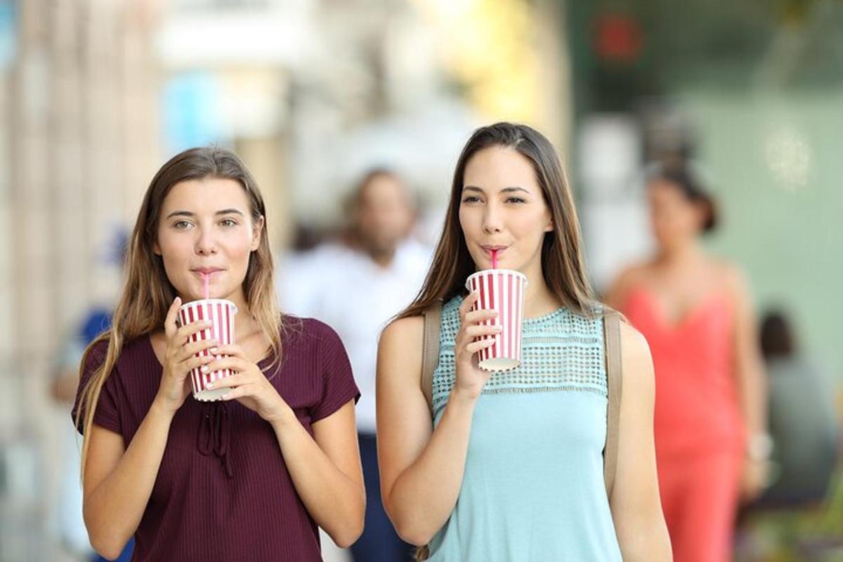 due donne che tengono i loro drink in bocca