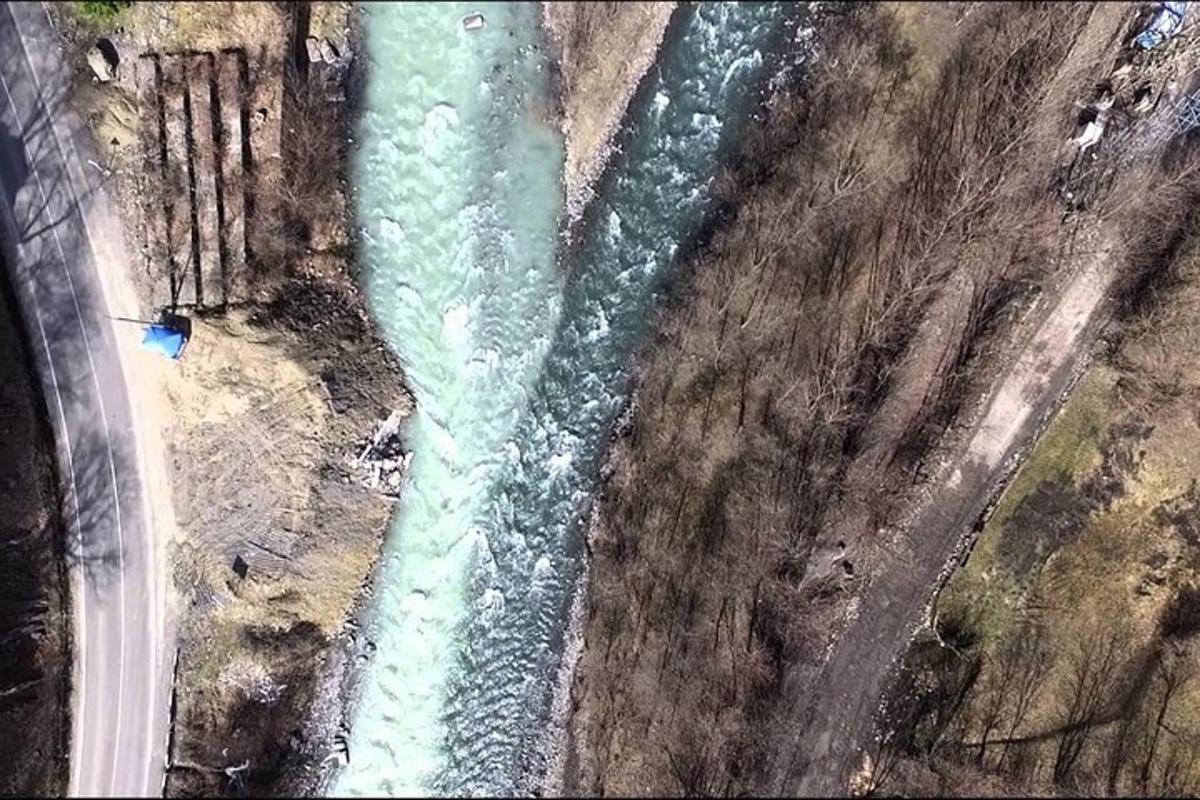 an aerial view of a river next to a road