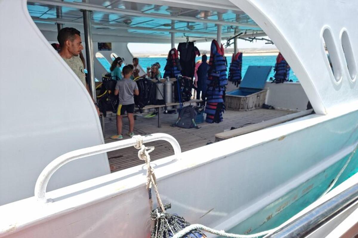 a group of people standing on the deck of a boat