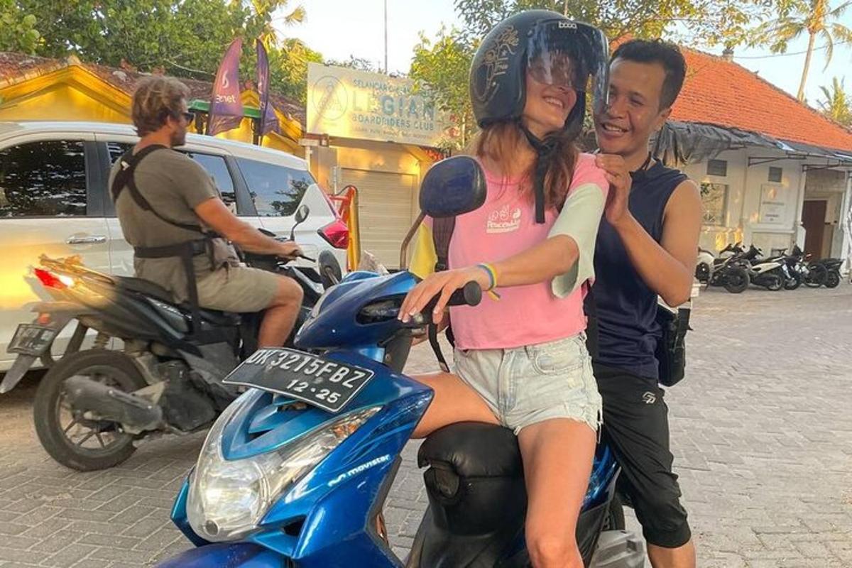 seorang lelaki dan seorang wanita duduk di atas motosikal