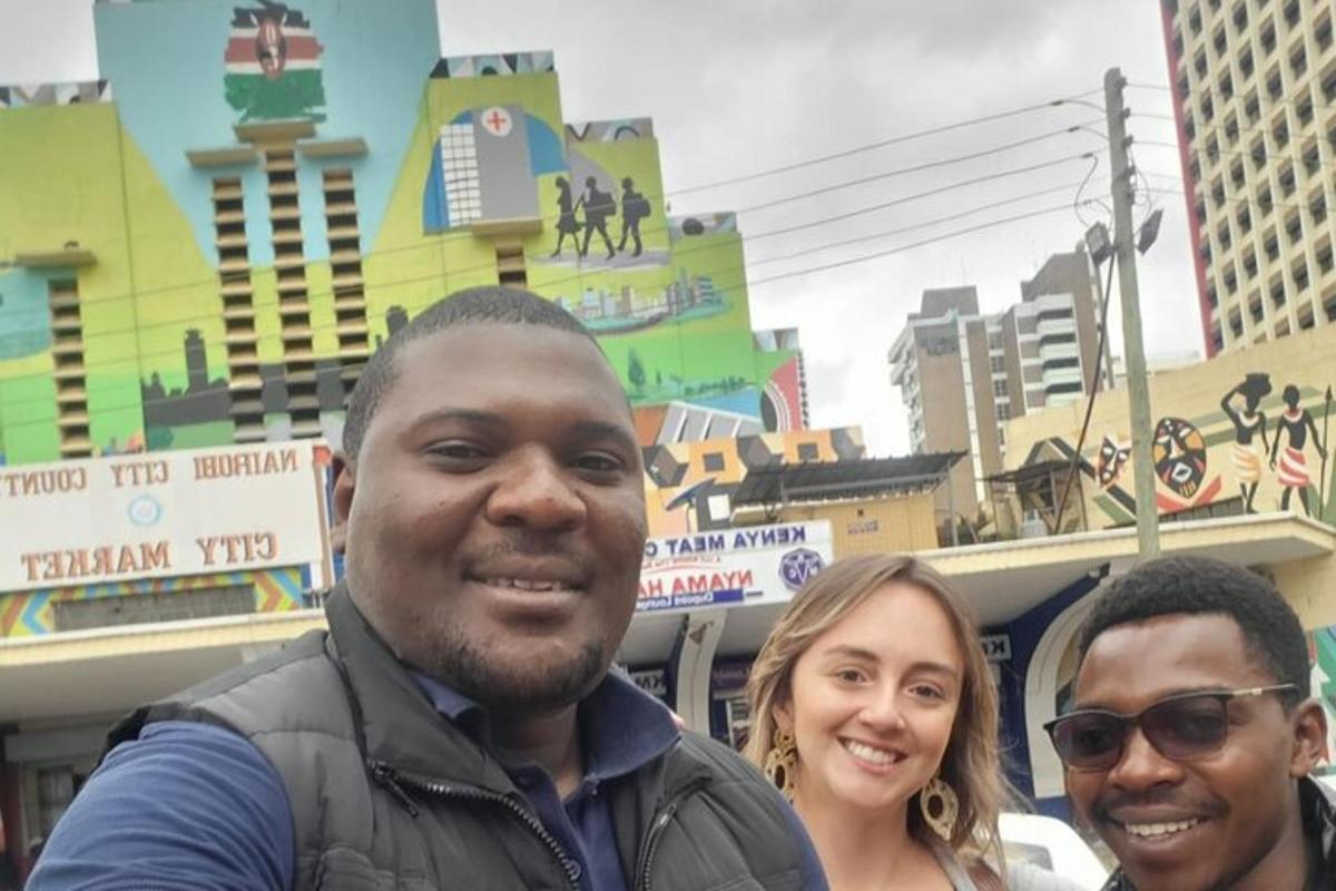 Un grupo de tres personas de pie frente a una ciudad.