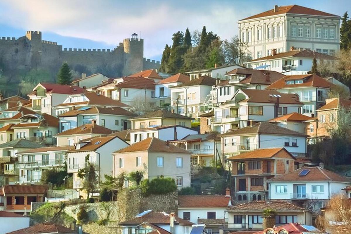 una città con case su una collina con un castello