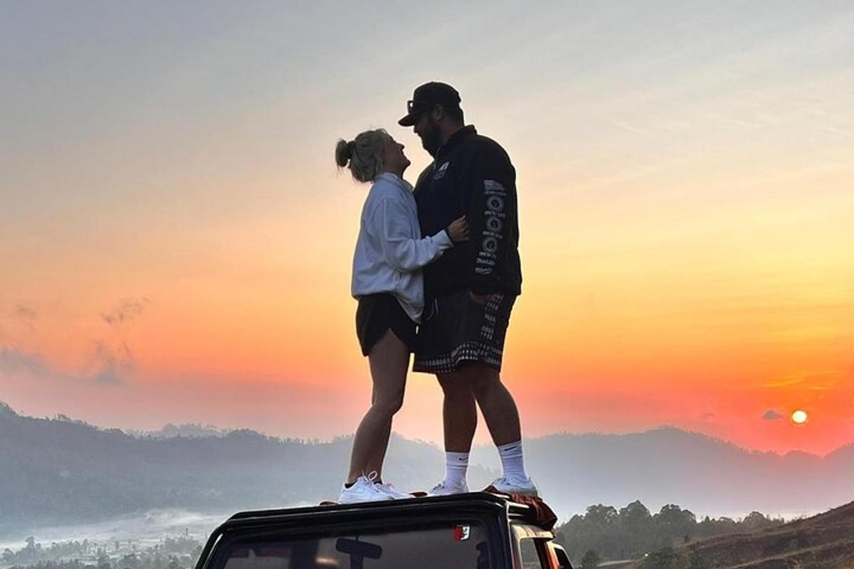 ein Mann und eine Frau stehen auf dem Dach eines Autos