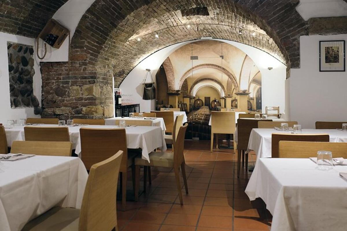 un ristorante con tavoli e sedie bianchi e un muro di mattoni