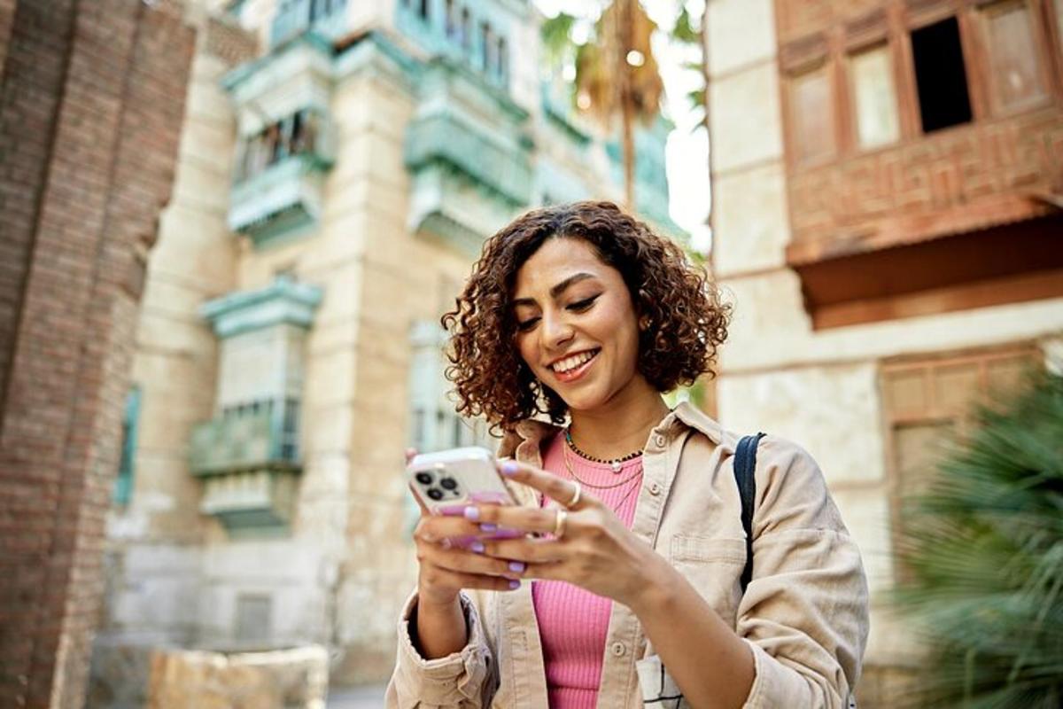 žena se směje a dívá se do svého mobilního telefonu