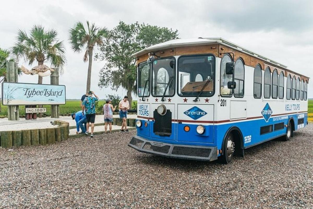 a blue and white bus parked on a gravel road