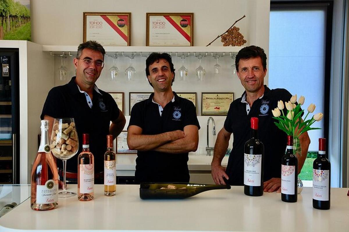 tres homes drets darrere d'un taulell amb ampolles de vi