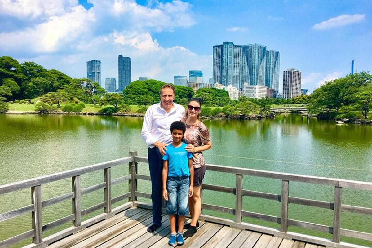 sebuah keluarga berdiri di atas jambatan kayu di hadapan sebuah tasik