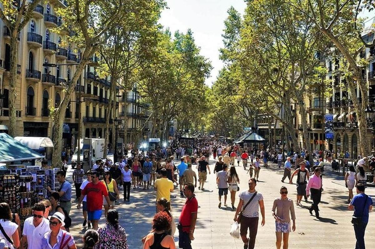 una multitud de gent caminant per un carrer concorregut de la ciutat