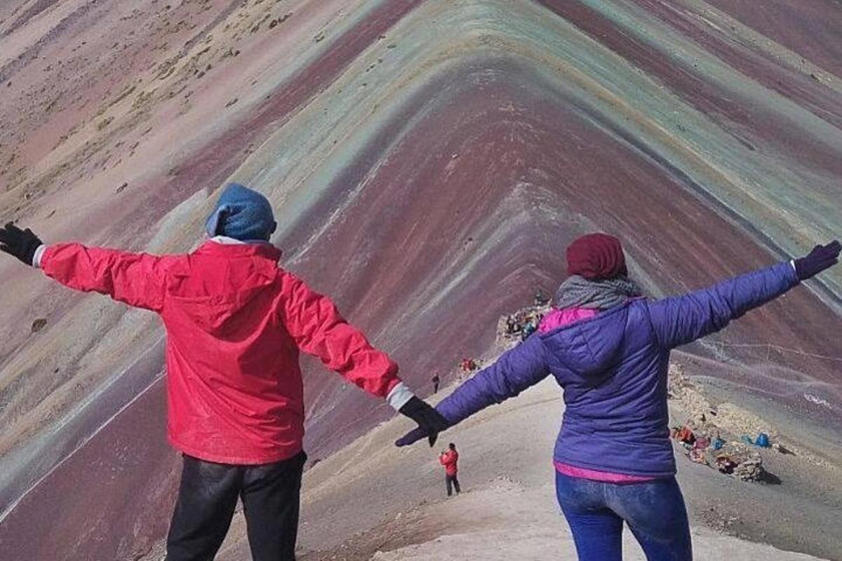 dva lidé stojící na pláži s rozpaženýma rukama