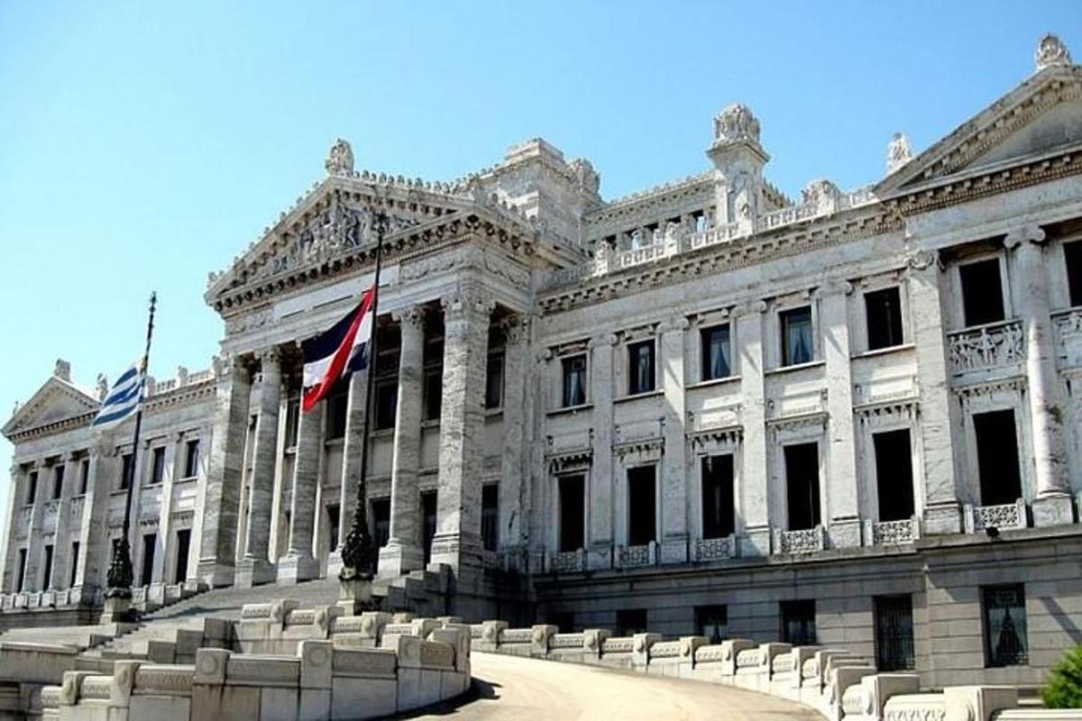 um grande edifício branco com bandeiras na frente