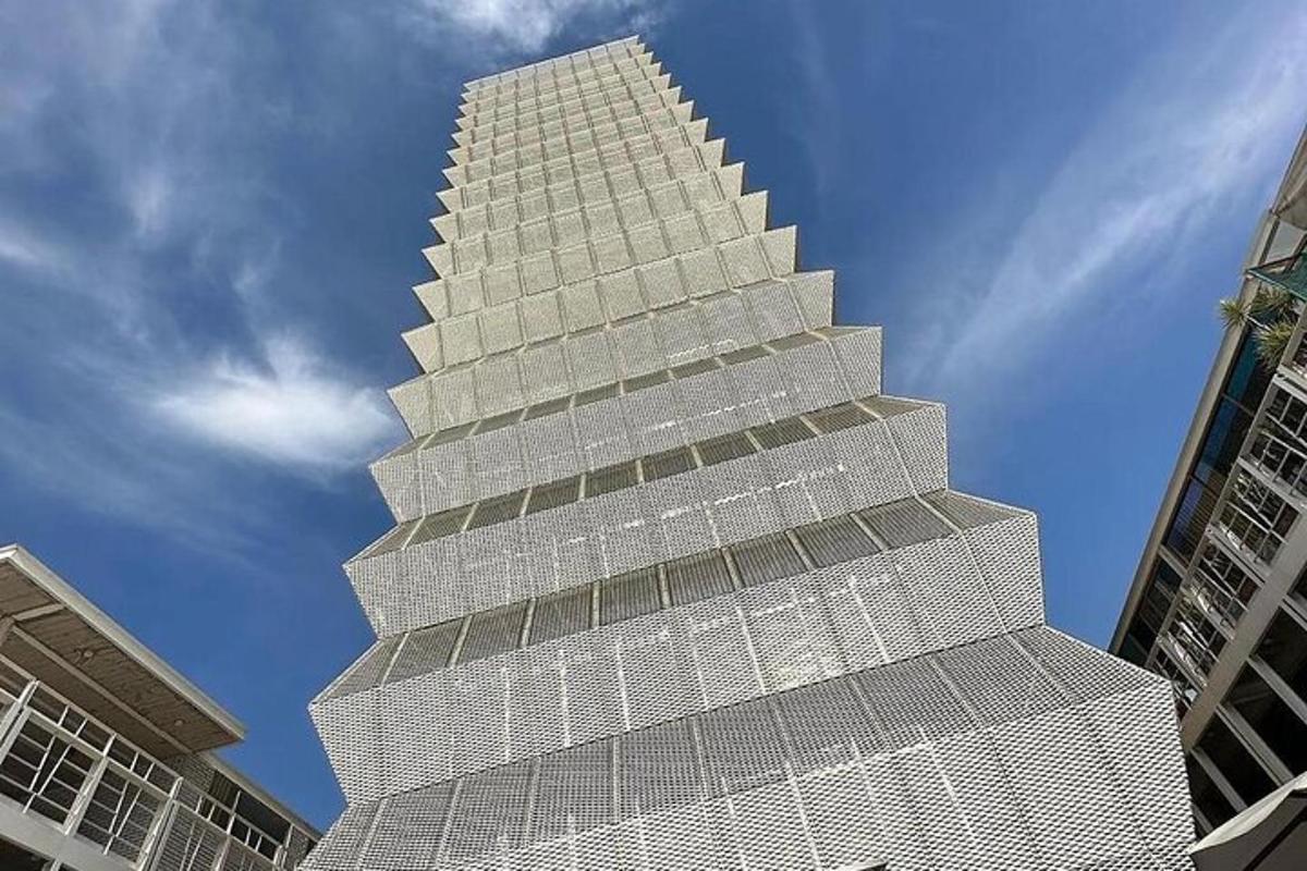 vysoká bílá budova s fasádou ve tvaru pyramidy
