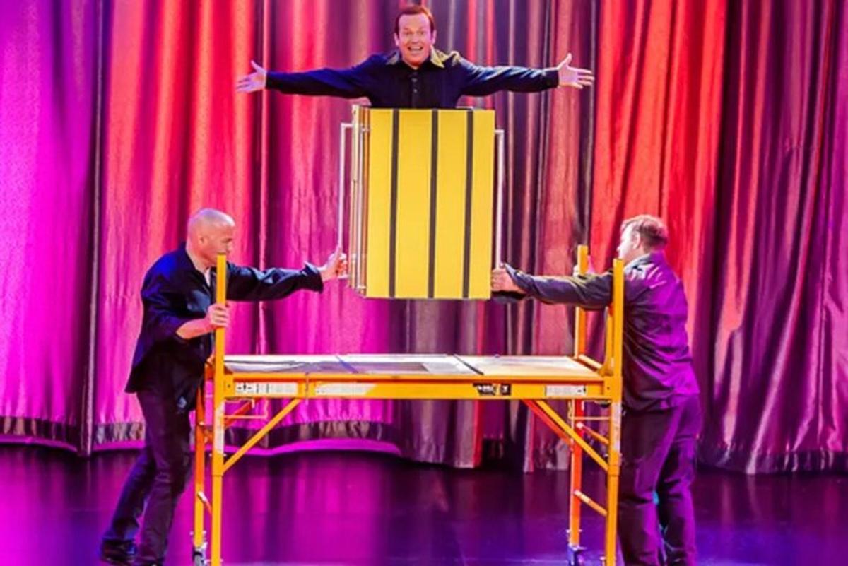 two men standing in front of a man on a podium