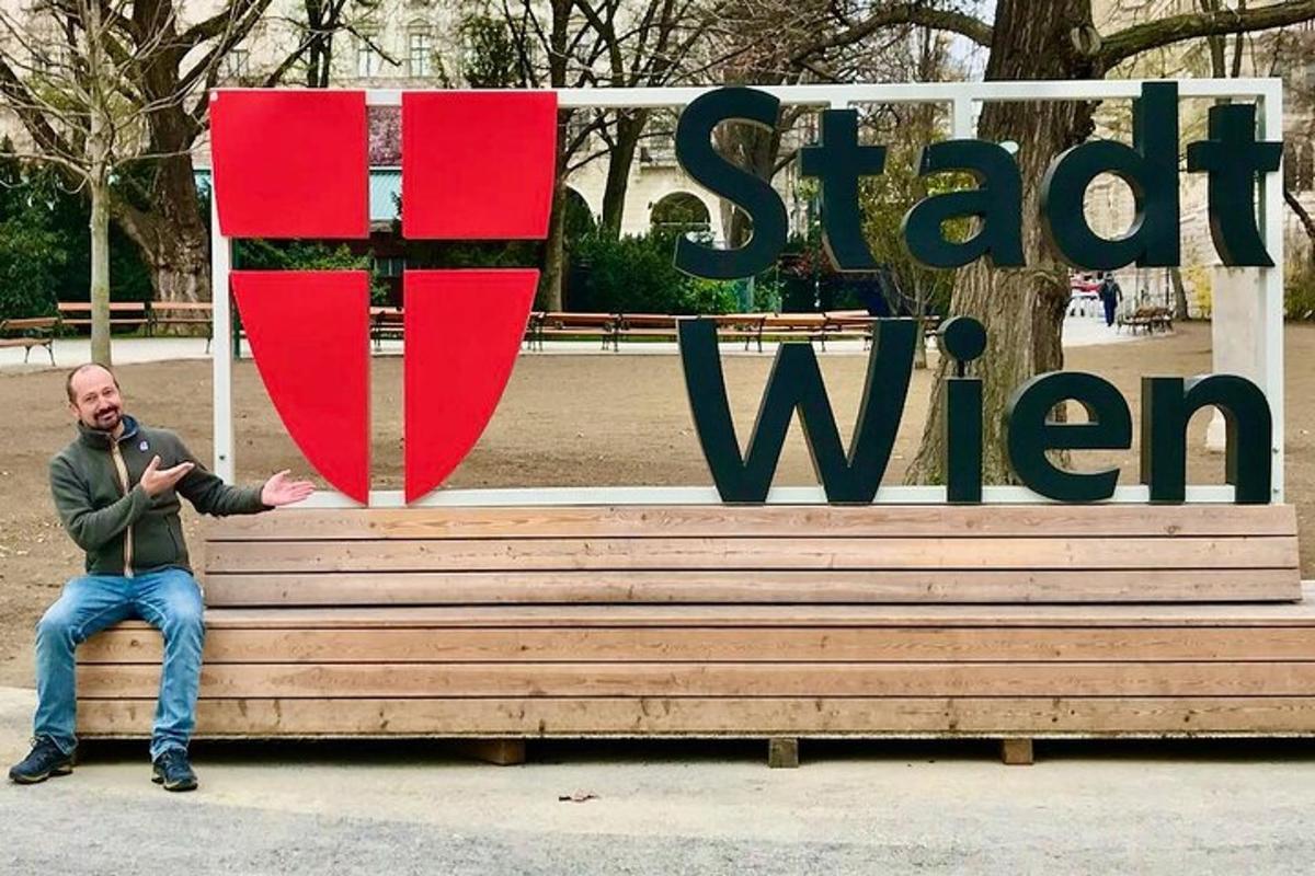 un home assegut en un banc davant d'un rètol