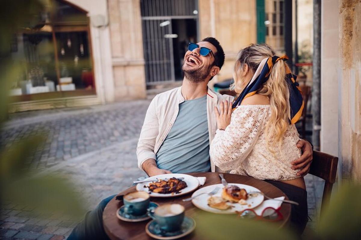 un uomo e una donna seduti a un tavolo con del cibo