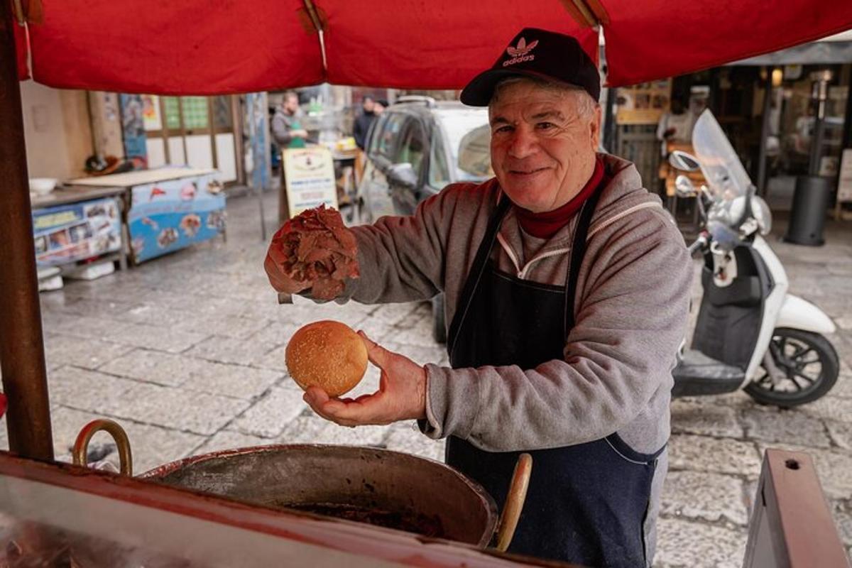 Egy idősebb férfi hot dogot süt a grillen