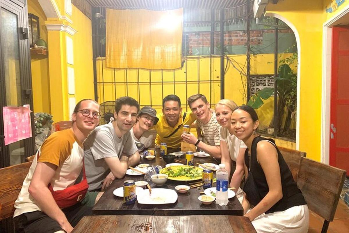 un gruppo di persone sedute a un tavolo che mangiano cibo