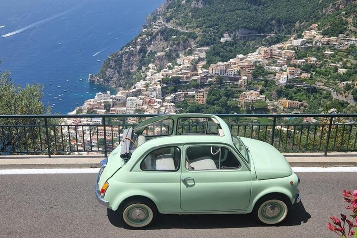 una piccola macchina verde parcheggiata sul fianco di una montagna