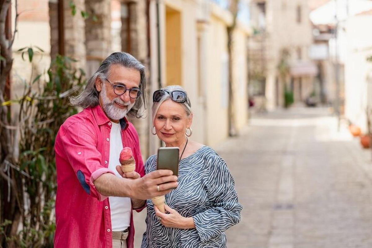 Starší muž a žena se dívají na mobilní telefon