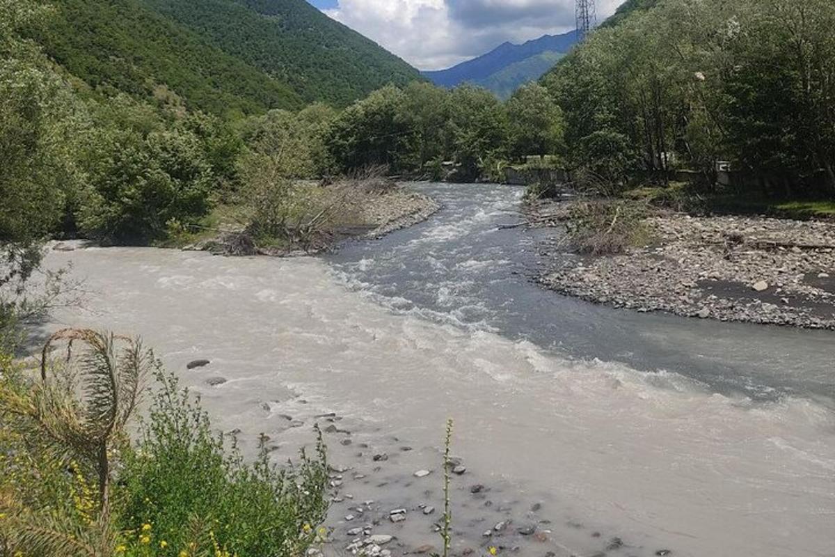 un fiume con rocce in mezzo a una montagna