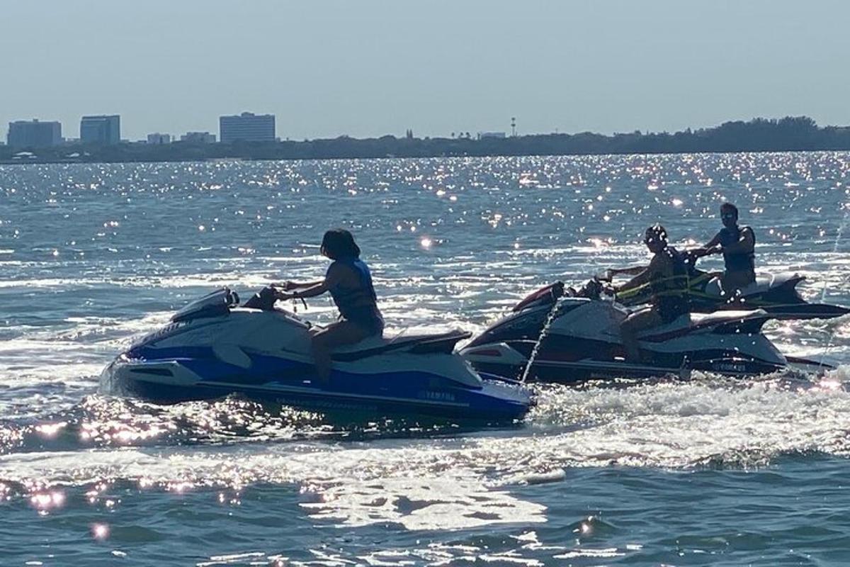 tiga orang menaiki jet ski di dalam air