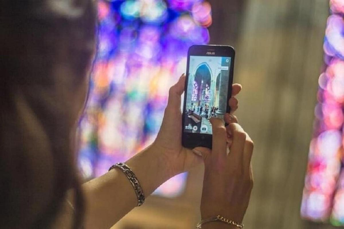 egy nő fényképez a mobiltelefonjával