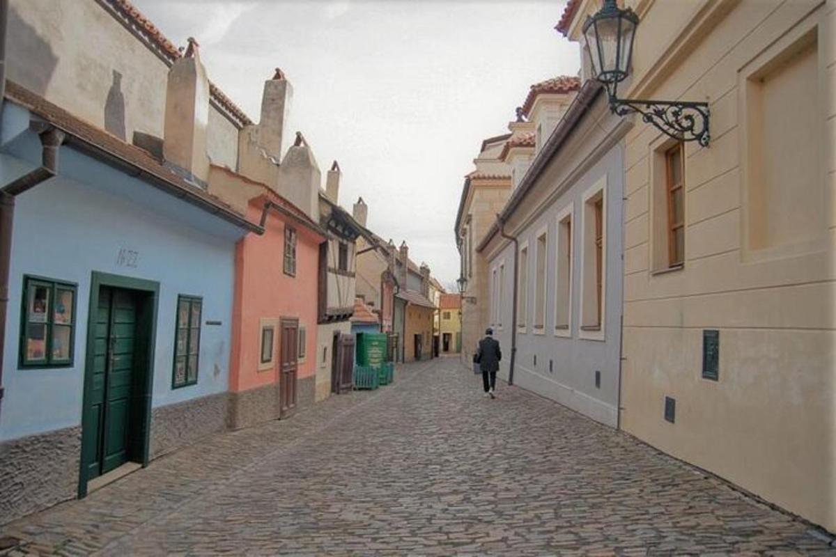 egy személy sétál egy macskaköves utcán, ahol épületek sorakoznak