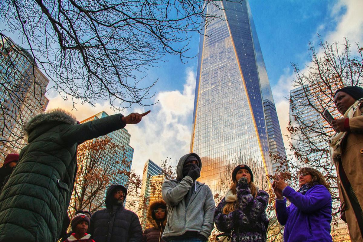Un grupo de personas de pie frente a un edificio alto.