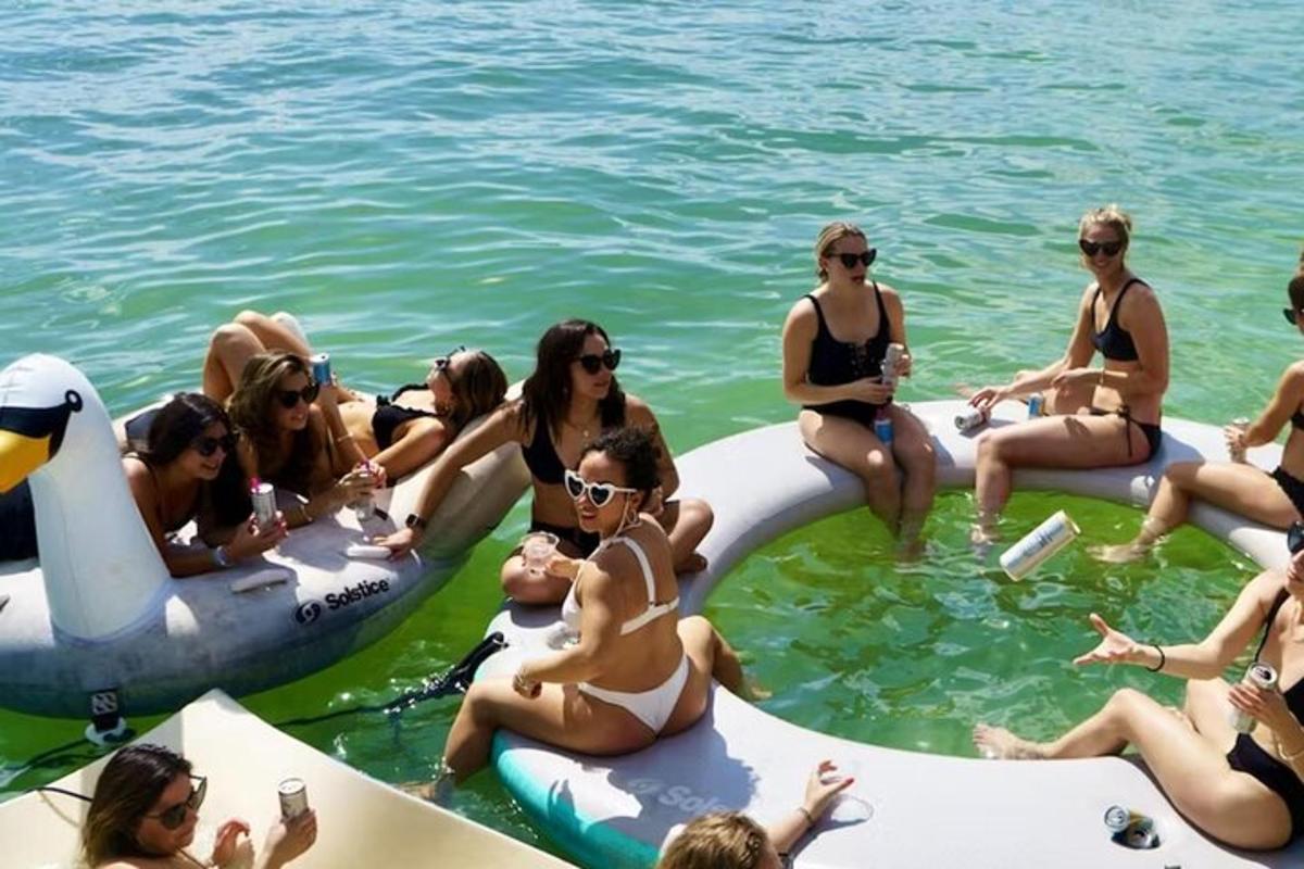 Un grupo de mujeres sentadas en el agua en inflables.