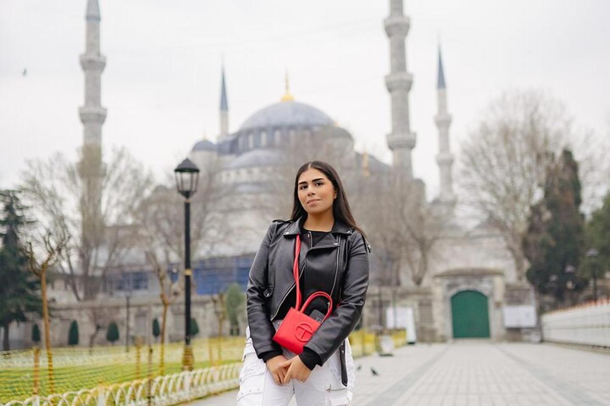caminin önünde duran kırmızı çantalı bir kadın