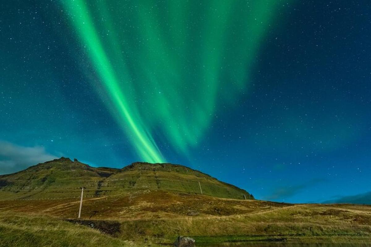un'aurora sopra una montagna sotto le stelle