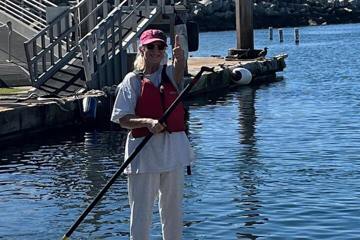 une femme debout dans l'eau tenant une pagaie