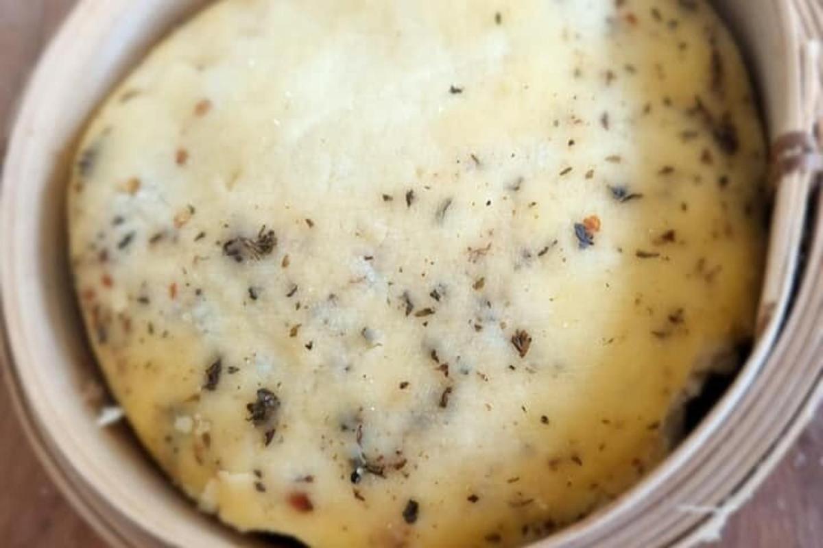 a close up of a pot of mashed potatoes with herbs