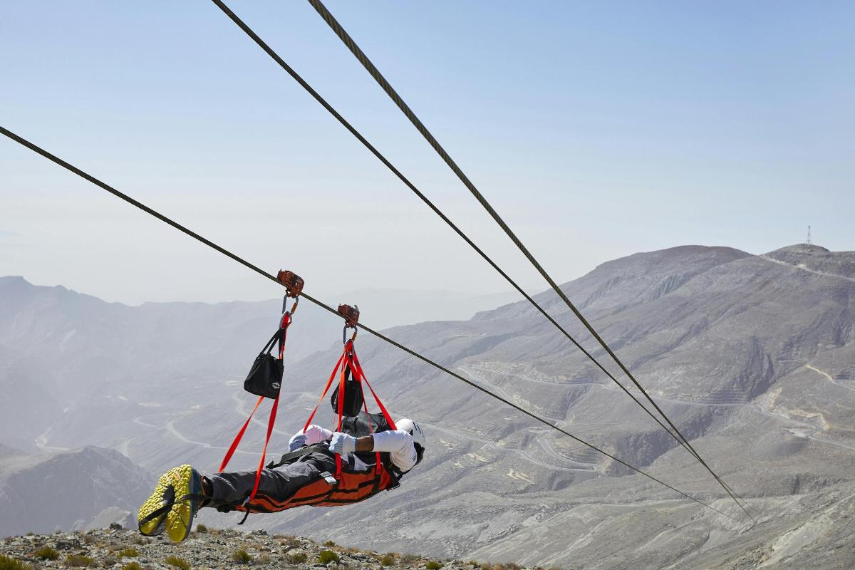 isang taong nakasabit sa isang zip line sa kabundukan